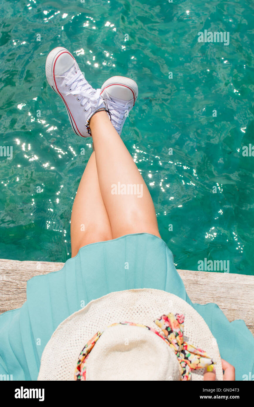 Frau Beine über dem Wasser auf einem Dock, Sommer relax Stockfoto