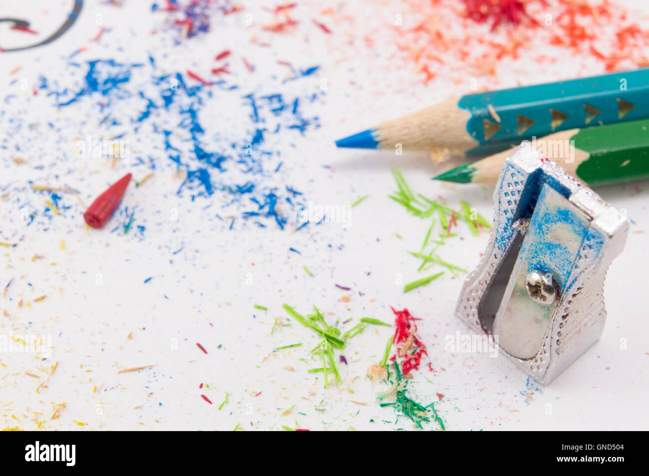 Weißes Papier bedeckt schärfen Reste mit zwei Bleistifte Buntstifte Stockfoto