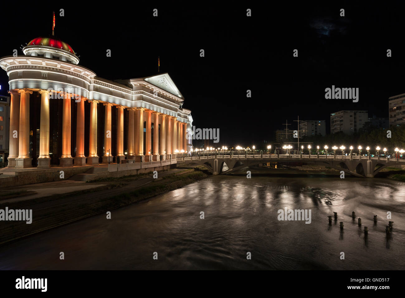 Nachtansicht des archäologischen Museums durch den Fluss Vardar in Skopje, Mazedonien Stockfoto