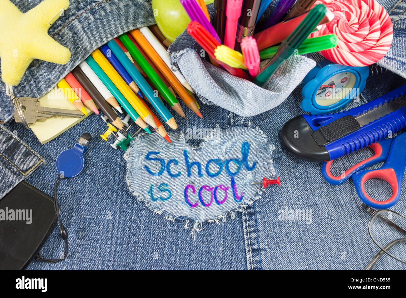 Schule ist cool Schild mit kreativen Lernobjekte auf Blue jeans Stockfoto