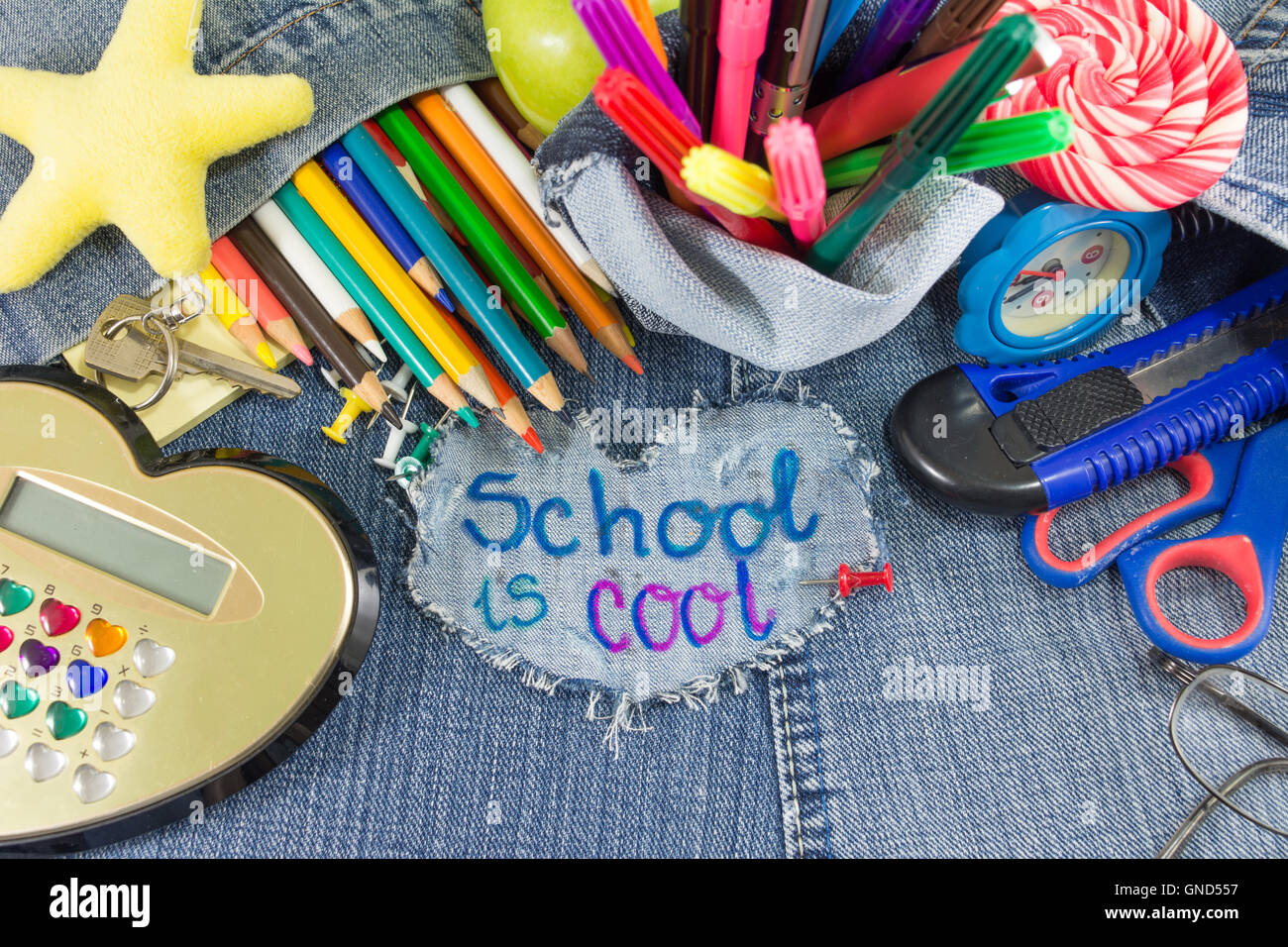 Schule ist cool Schild mit kreativen Lernobjekte auf Blue jeans Stockfoto