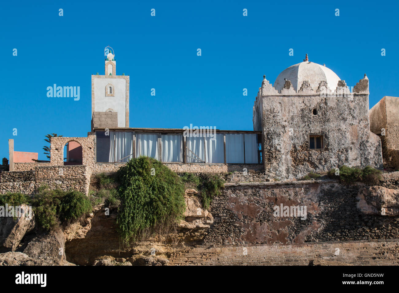 Kleine Moschee im Dorf auf der Küste des Atlantischen Ozeans in Marokko, Moulay Bouzerktoun. Strahlend blauer Himmel. Stockfoto