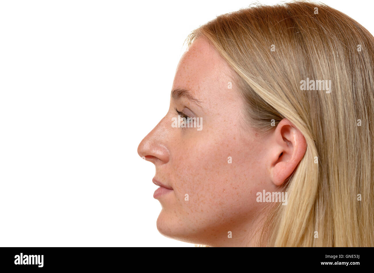 Profil-Seitenansicht des Gesichts eine attraktive blonde Frau mit ihren langen Haaren versteckt hinter ihrem Ohr isoliert auf weiss Stockfoto
