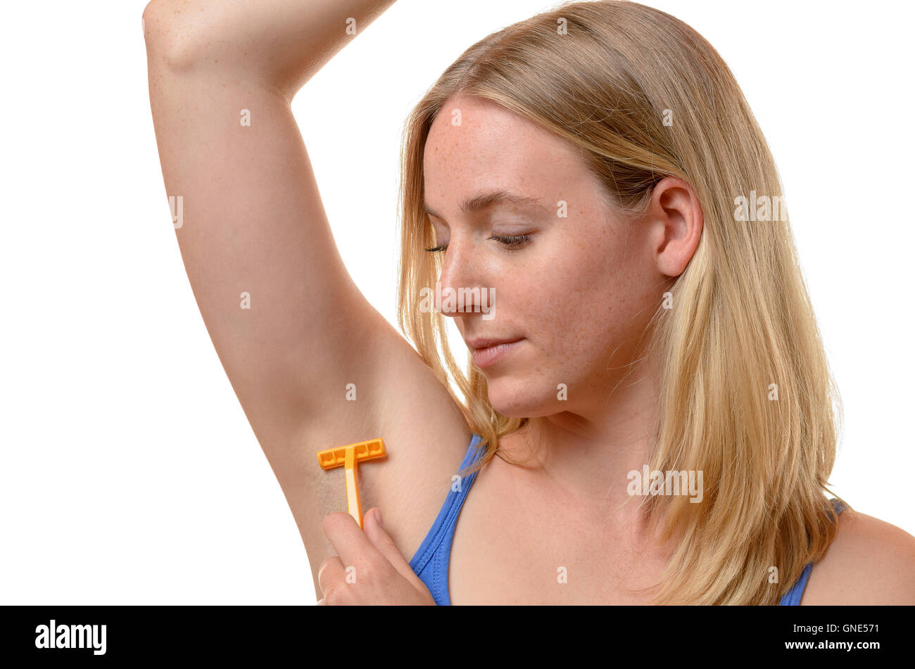 Frau rasieren ihr Unterarm mit einem kleinen gelben Kunststoff Einwegrasierer in einer Nahaufnahme, isoliert auf weiss Stockfoto