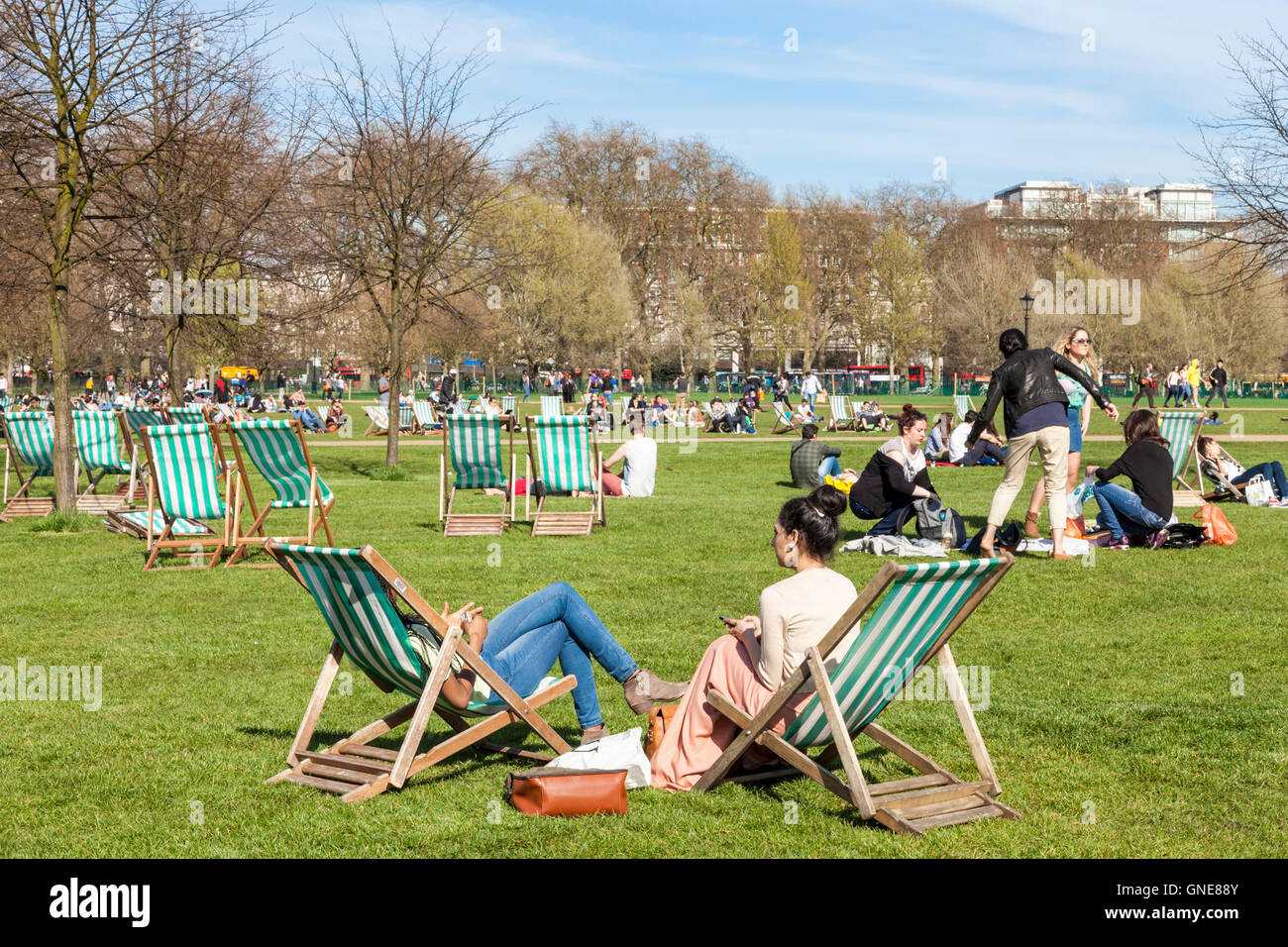 Menschen entspannend in der Frühlingssonne am Hyde Park, London, England, Großbritannien Stockfoto