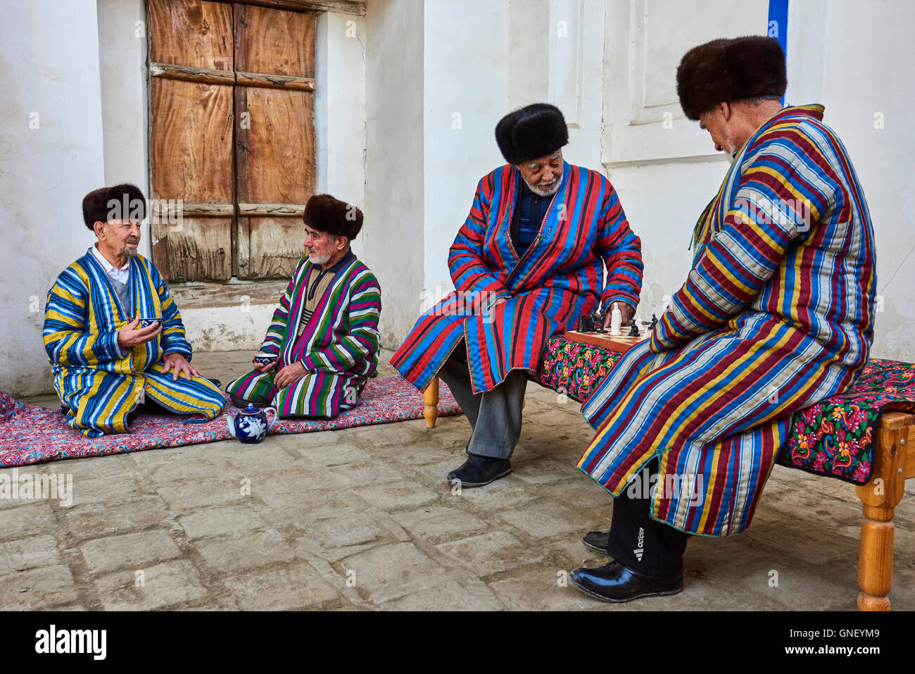 Usbekistan, Buchara, UNESCO-Welterbe, usbekische Männer spielen Schach in  traditioneller Kleidung Stoff Stockfotografie - Alamy