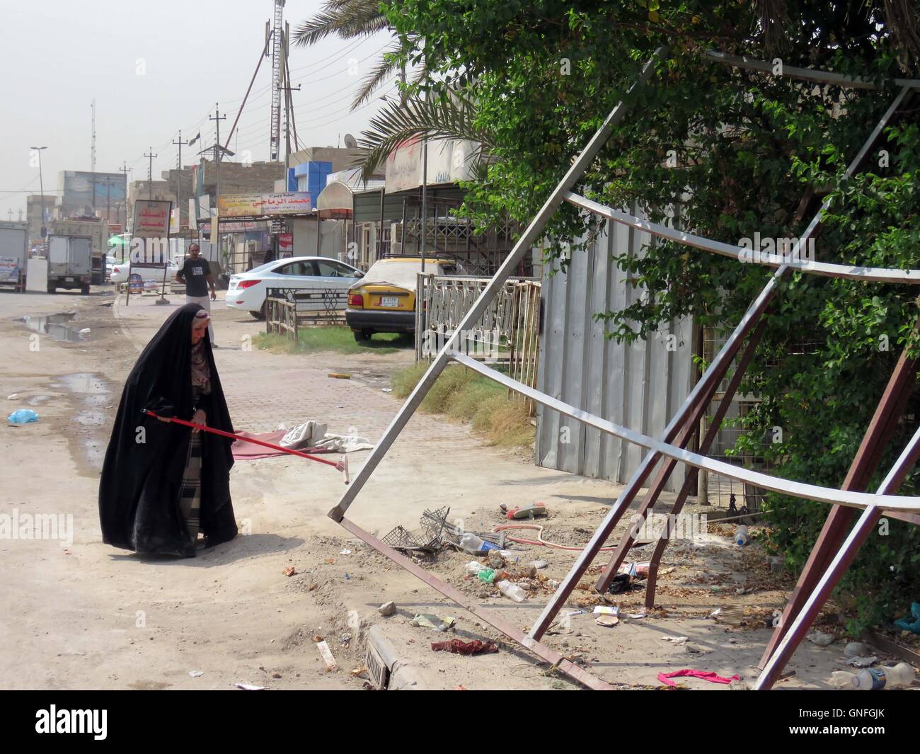 Bagdad, Irak. 31. August 2016. Eine Frau reinigt die Straße nach einem Selbstmordanschlag in Eilam Nachbarschaft in Bagdad, Südirak, 31. August 2016. Der Angriff ereignete sich am Dienstag Abend, als ein Selbstmordattentäter mit explosiven Weste, selbst an der überfüllten Darwish Kreuzung in Eilam Nachbarschaft in südlichen Bagdad gezündet, verlassen mindestens zwei Menschen getötet und acht weitere verletzt, die Quelle sagte Xinhua unter Berufung auf ersten Bericht. © Khalil Dawood/Xinhua/Alamy Live-Nachrichten Stockfoto