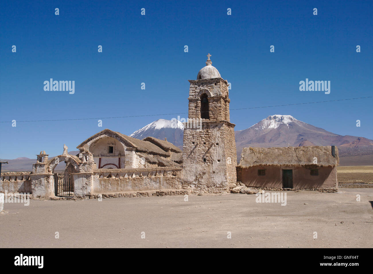 Kirche im Dorf Sajama mit Parinacota und Pomerape Vulkane, Altiplano, Bolivien Stockfoto