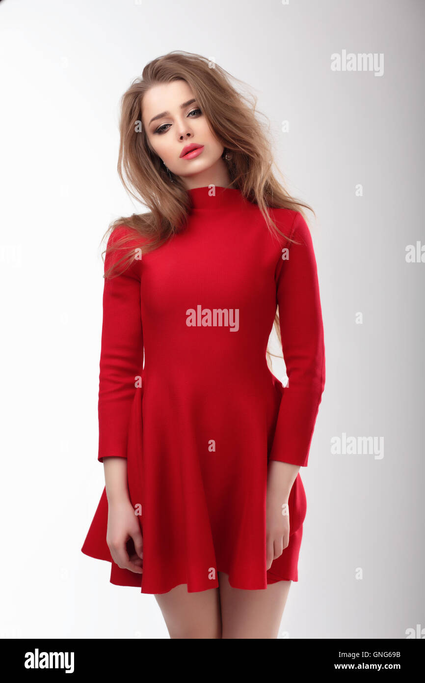 Junge Frau in einem roten Kleid auf einem weißen Hintergrund. Mode. Stockfoto