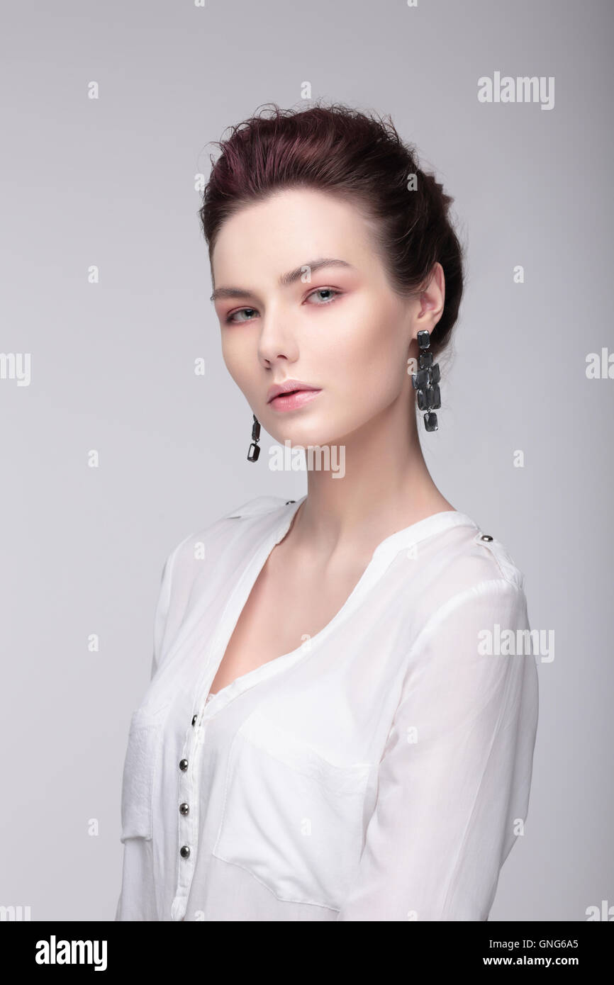 Stilvolle Bildnis einer Frau. Mode. Eine weiße Bluse. Große Ohrringe. Stockfoto
