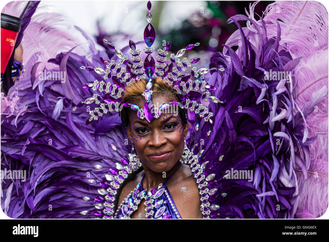 Schöne Afro-Karibische Frau in Tracht auf dem Notting Hill Carnival in Westlondon in lila Federn Stockfoto
