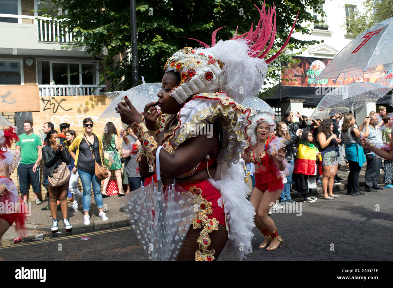 NottingHill Carnival 2016. Eine junge Frau, die Teilnahme an der Karnevalsumzug stoppt erneut Lippenstift Stockfoto