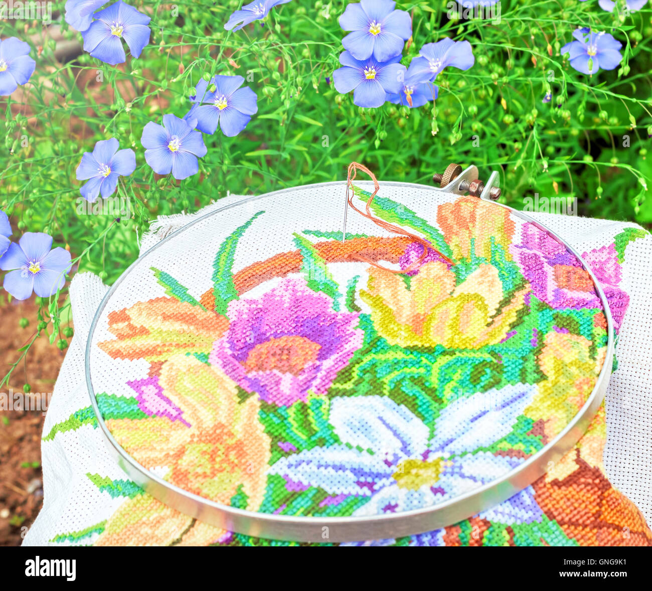Schöne Stickereien und Blumen von blauem Leinen am sonnigen Sommertag Stockfoto