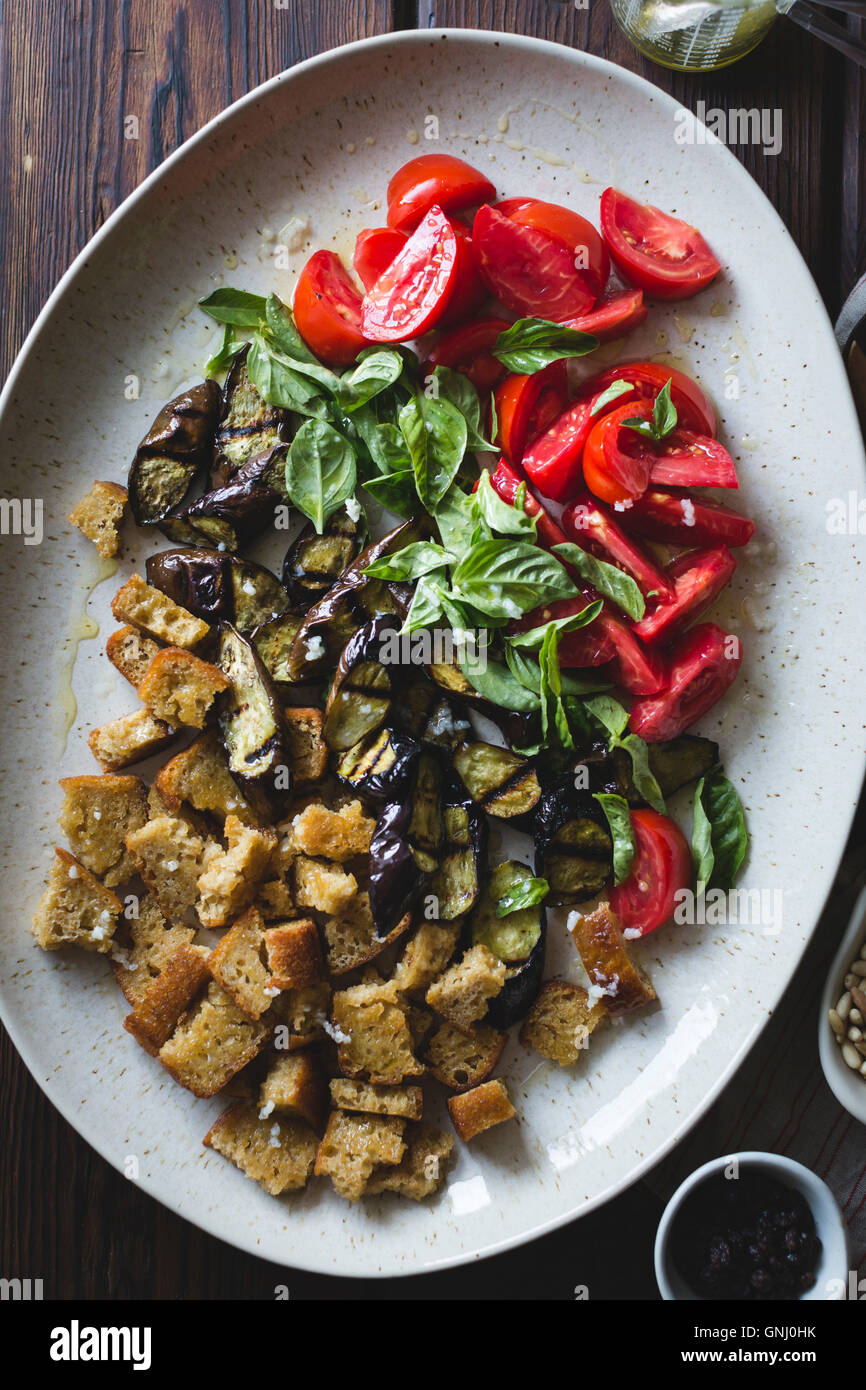 Aubergine Panzanella mit Kapern, Oliven und Pinienkerne, geröstet, glutenfrei. Stockfoto