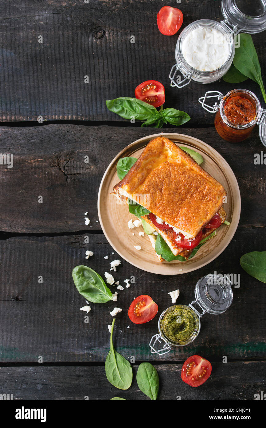 Low-Carb glutenfrei Cloud Brot vegetarischen Sandwich mit Spinat, Avocado, Feta Käse, Tomaten und Pesto-Sauce, serviert auf Platte w Stockfoto