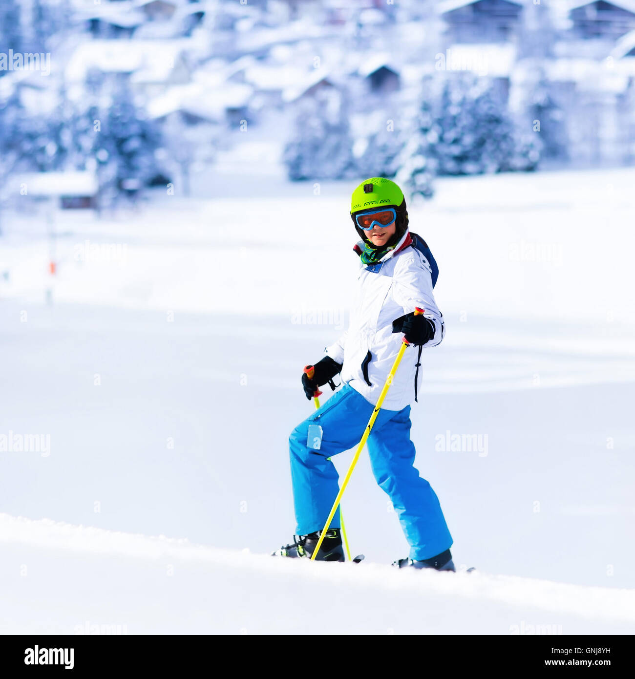 Kind beim Skifahren in Bergen. Aktive Teenager-Alter Kind mit Helm, Schutzbrille und Polen. Skirennen für Kleinkinder. Wintersport Stockfoto