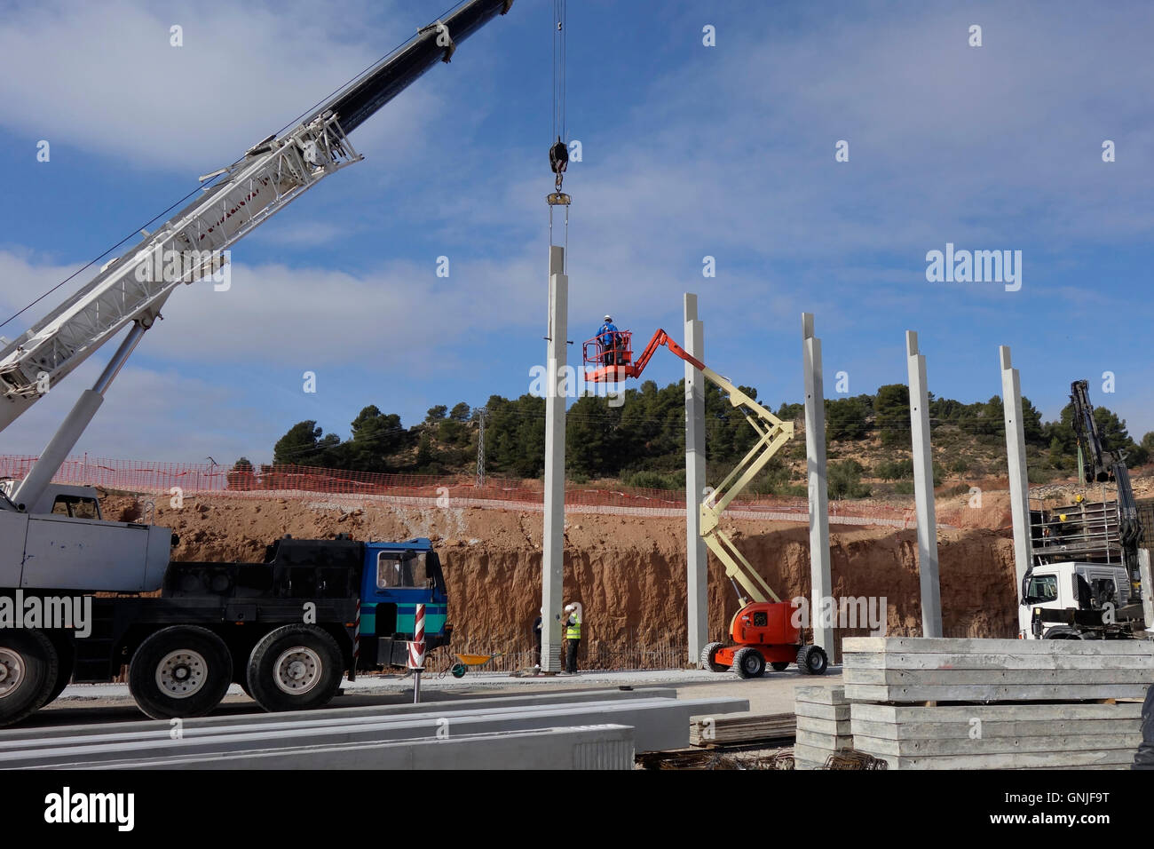 Baustelle, Krane und LKWs mit Betonsäulen Stockfoto