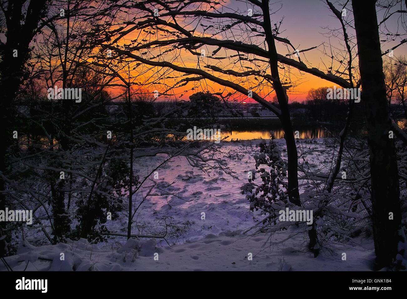 Roter Sonnenuntergang, Silhouetten von Schnee bedeckten Baum Zweige, verschneite Landschaft, Raummotive eine der Lesum, Blick Nach Lesumbrok, St Magnus, Deutschland Stockfoto