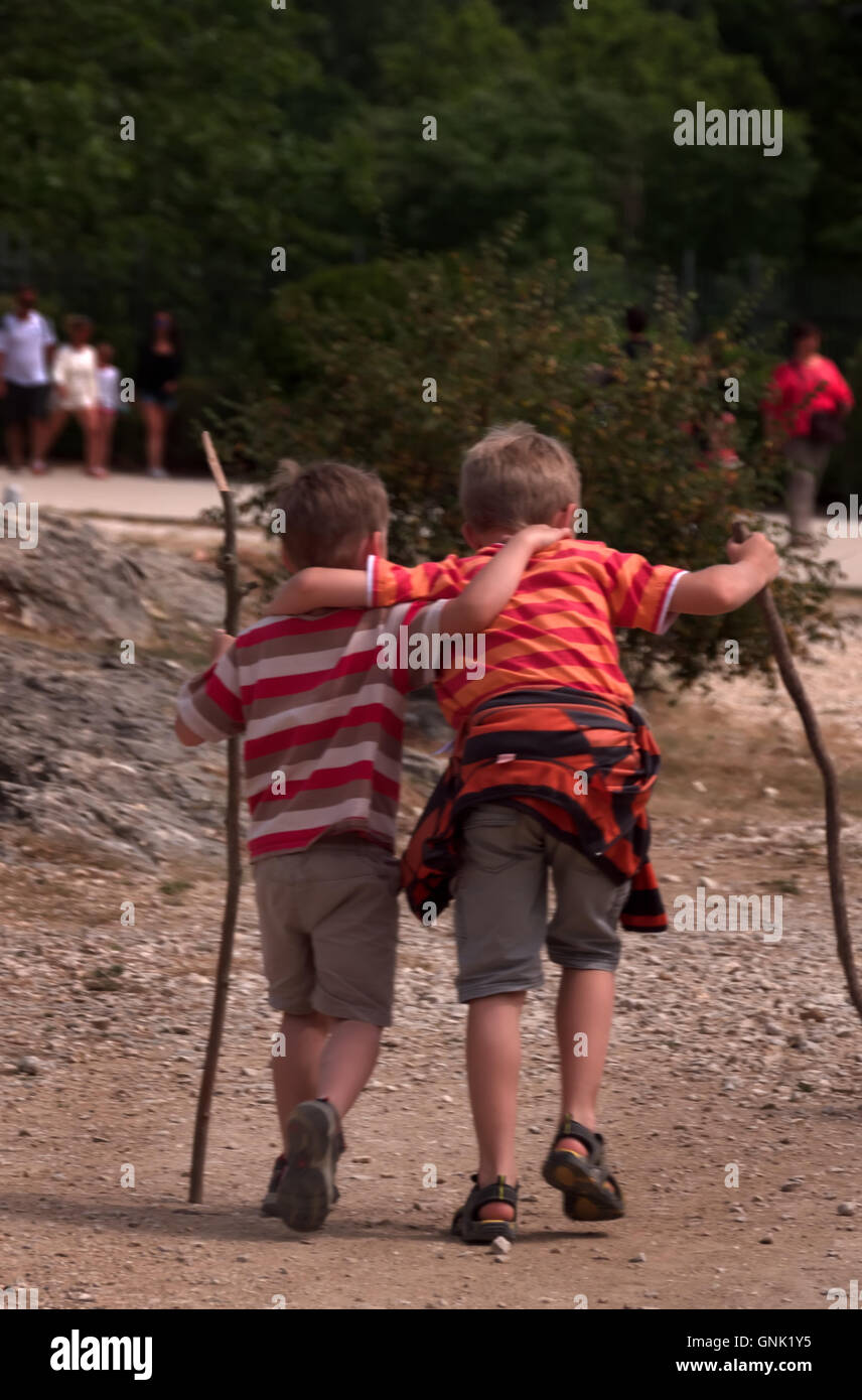 Zwei Jungs umarmen sich und gehen zusammen in der Nähe von Pont du Gard, Frankreich. Junge männliche Freunde, die spielen und Spaß haben Stockfoto
