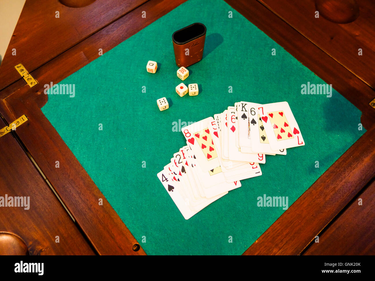 Vintage Gambling-Tabelle mit Spielkarten und Würfel, grünen Hintergrund. Stockfoto