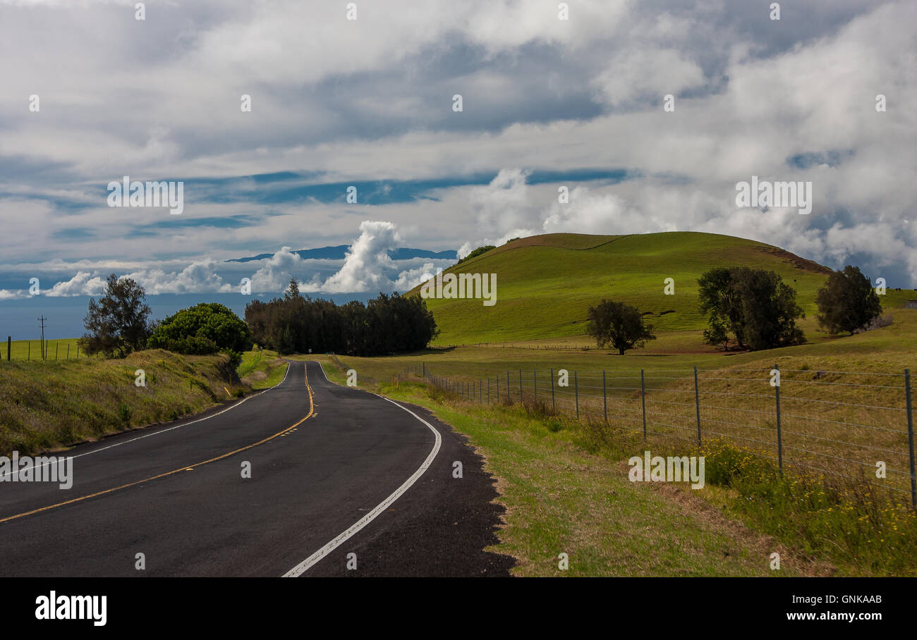 Landschaft mit einem grasbewachsenen Hügel und eine asphaltierte Straße Stockfoto