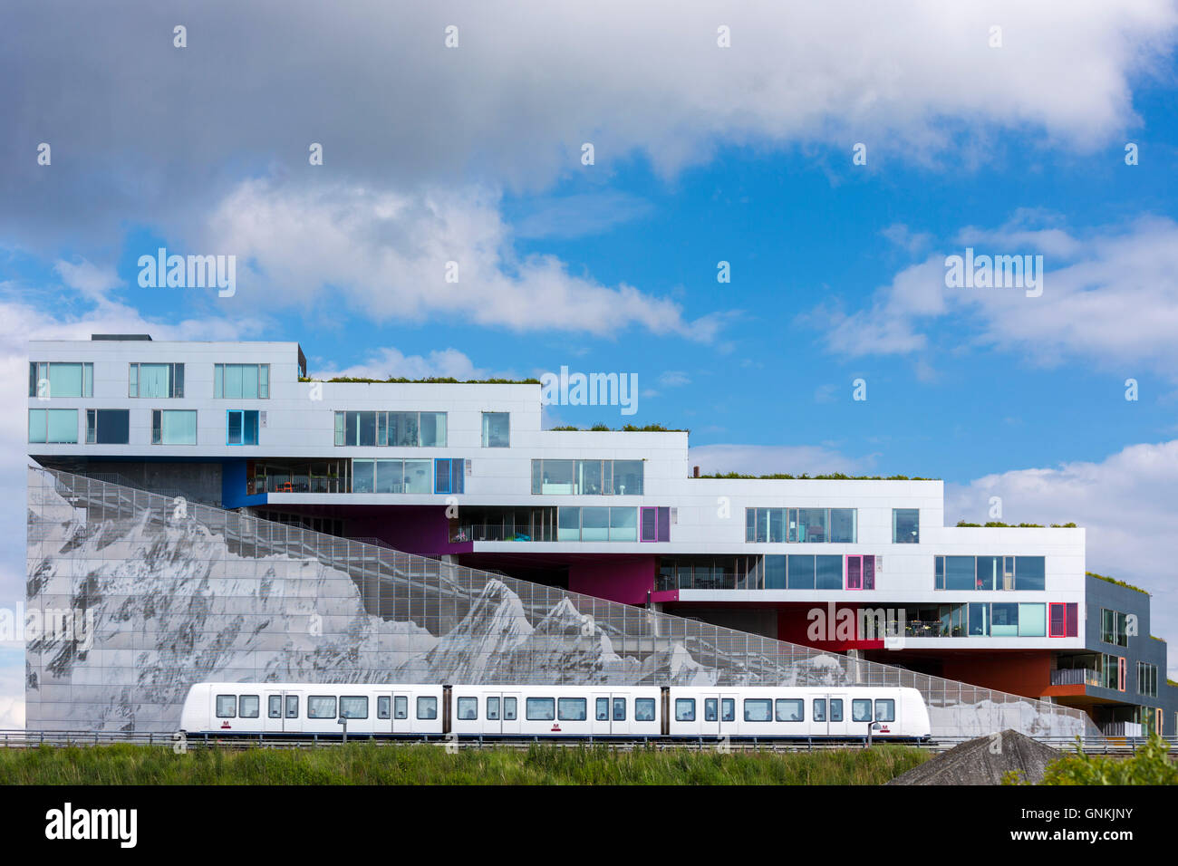 Ultra-moderne Neubauwohnungen mit Bergkette unten und Zug auf Orestads Boulevard, Kopenhagen, Dänemark Stockfoto