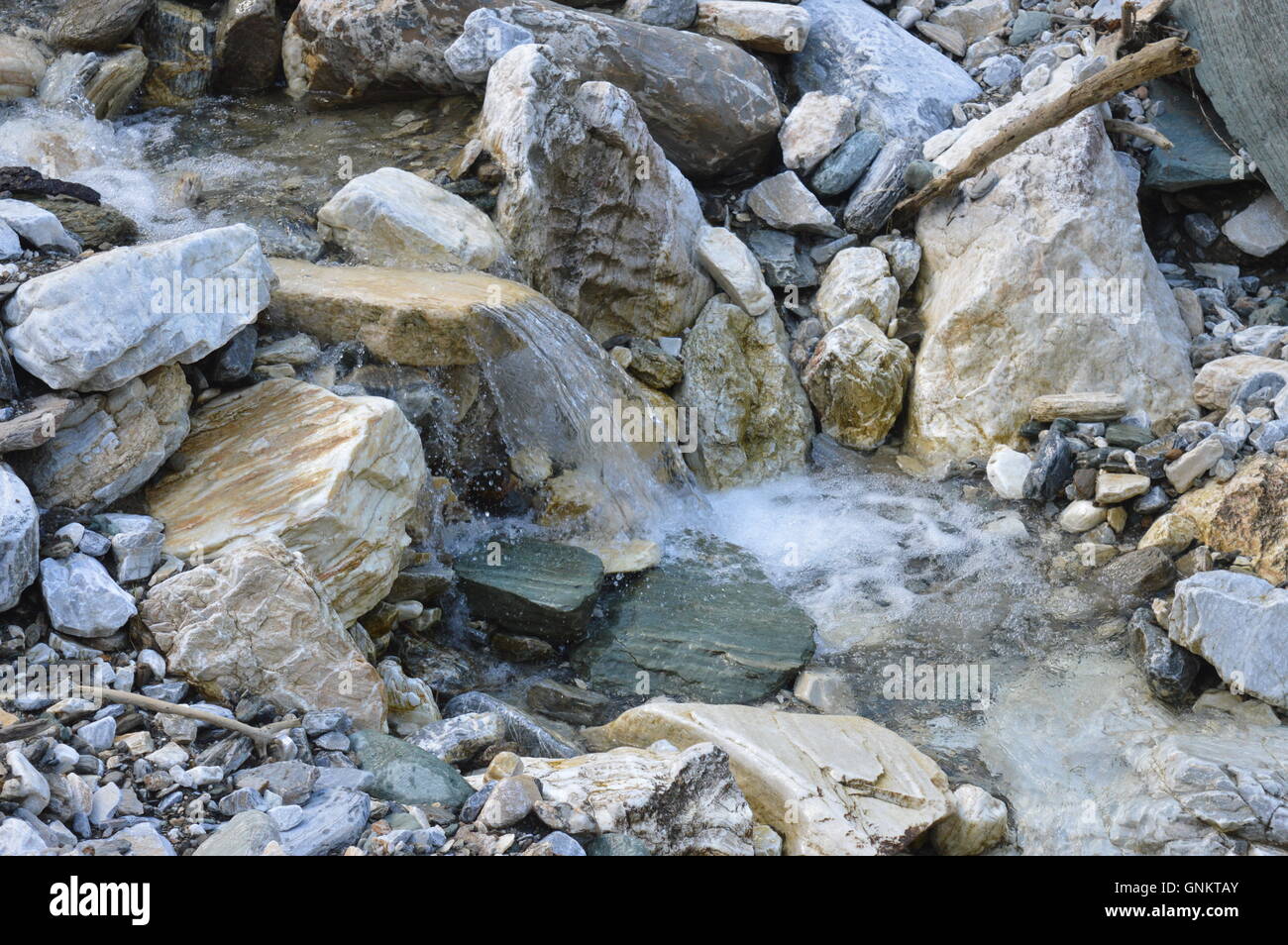 Ein Strom von klarem Wasser fließt über die Felsen Stockfoto
