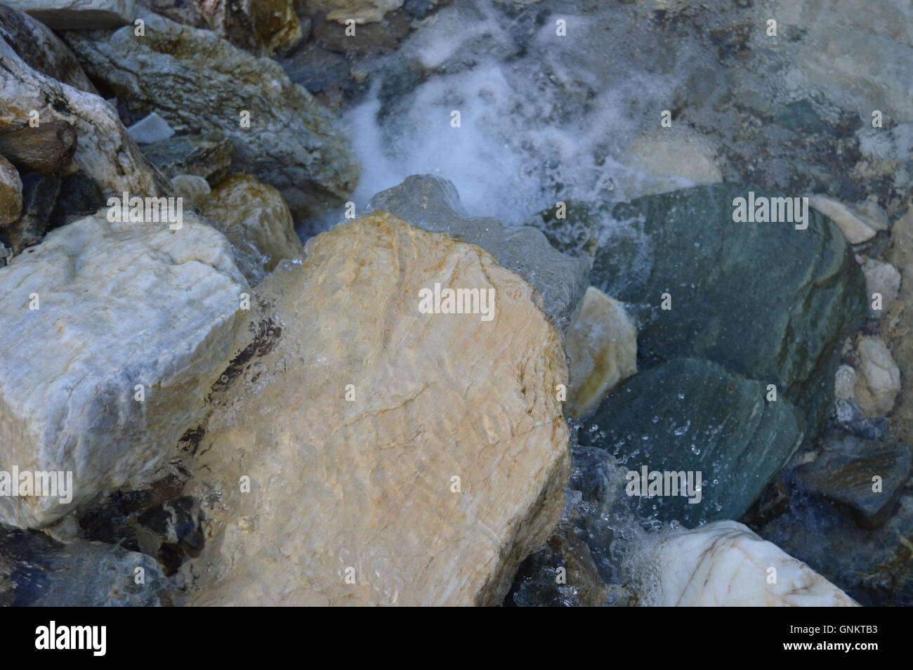 Wasser fließt über einen Felsen bilden einen kleinen Wasserfall Stockfoto