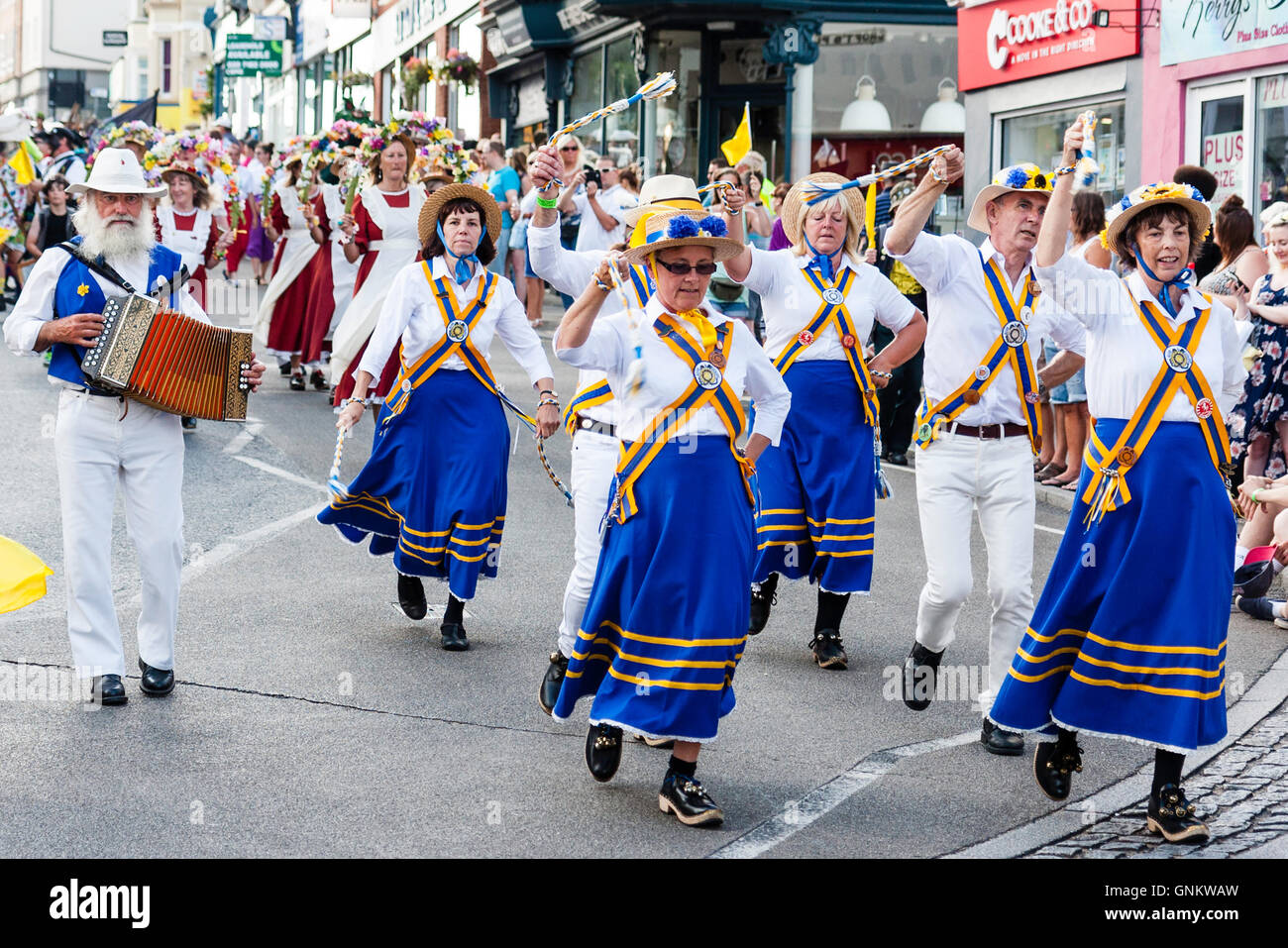 Broadstairs Folk Woche Festival. Parade. Quicklebendig Morris Seite tanzen mit Morris Mann spielt Akkordeon, wie Sie entlang der Straße entlang der Stadt. Stockfoto