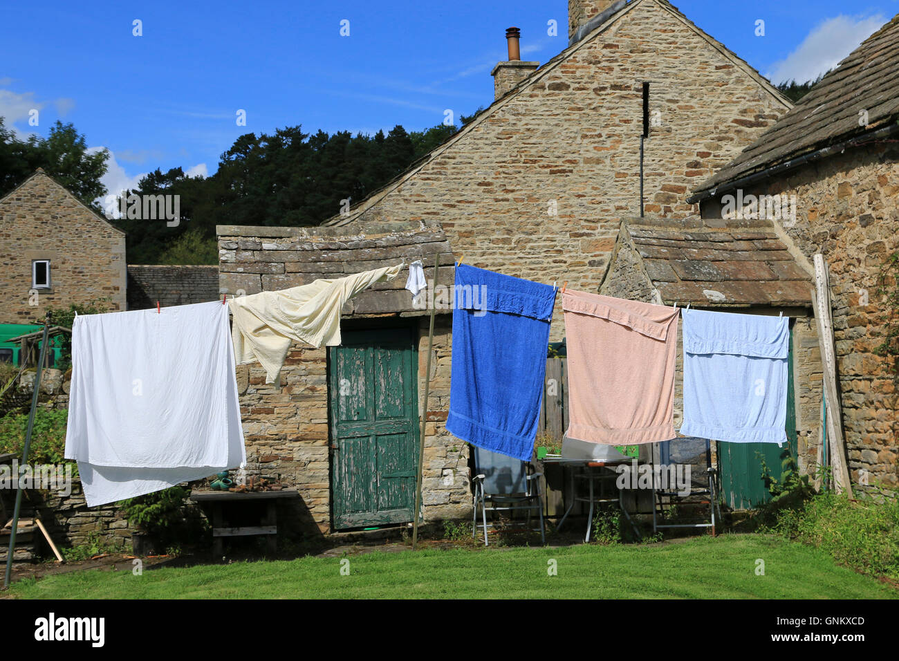 Wäsche zum Trocknen auf eine Wäscheleine an einem sonnigen Tag draußen hängen Stockfoto