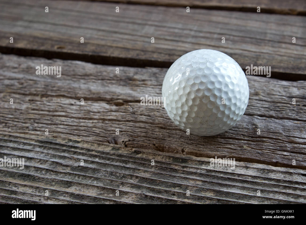 Alte gebrauchte Golfball auf hölzernen Hintergrund Stockfoto