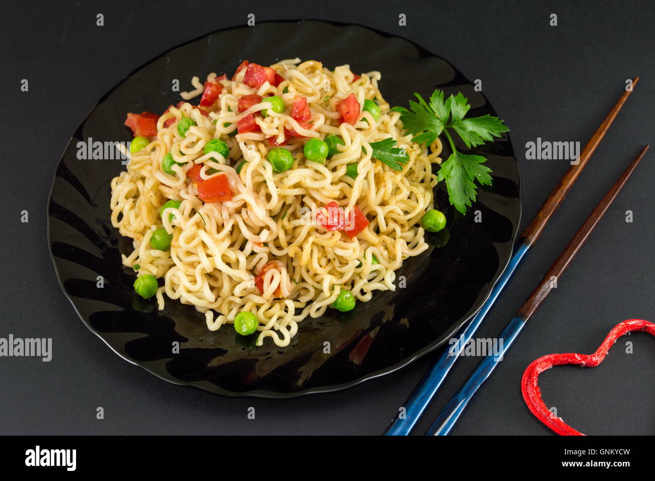 Zubereitete Nudeln mit Tomaten und Erbsen auf einem Teller Stockfoto