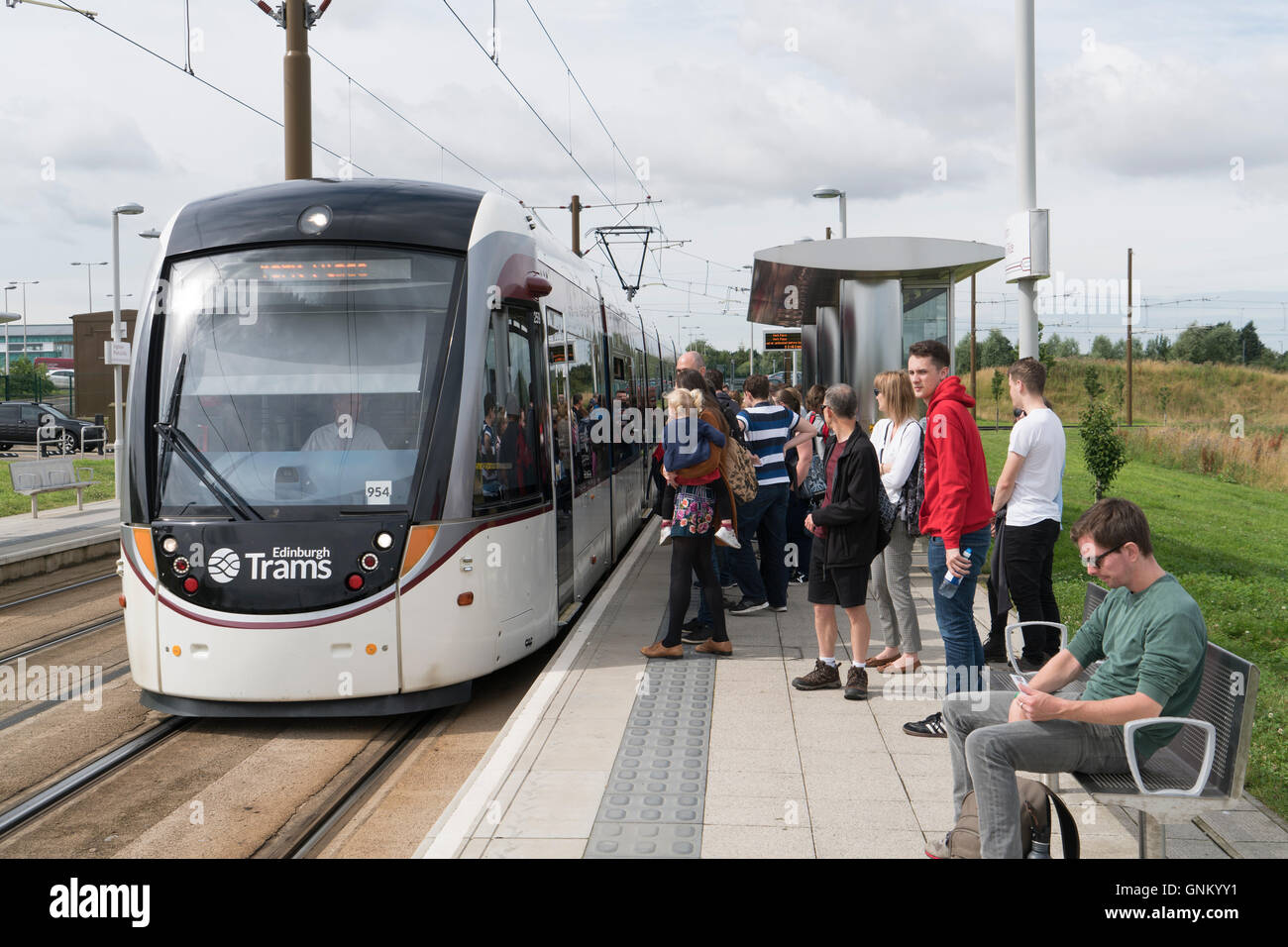 Menschen warten auf neue Edinburgh Tram an Ingleston Park &amp; Ride in Edinburgh, Schottland, Vereinigtes Königreich an Bord. Stockfoto