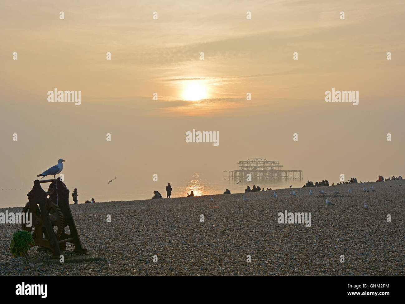 Strand, Meer und alten stillgelegten West Pier in Brighton, East Sussex, England im Meer Nebel, am späten Nachmittag. Mit Menschen am Strand Stockfoto