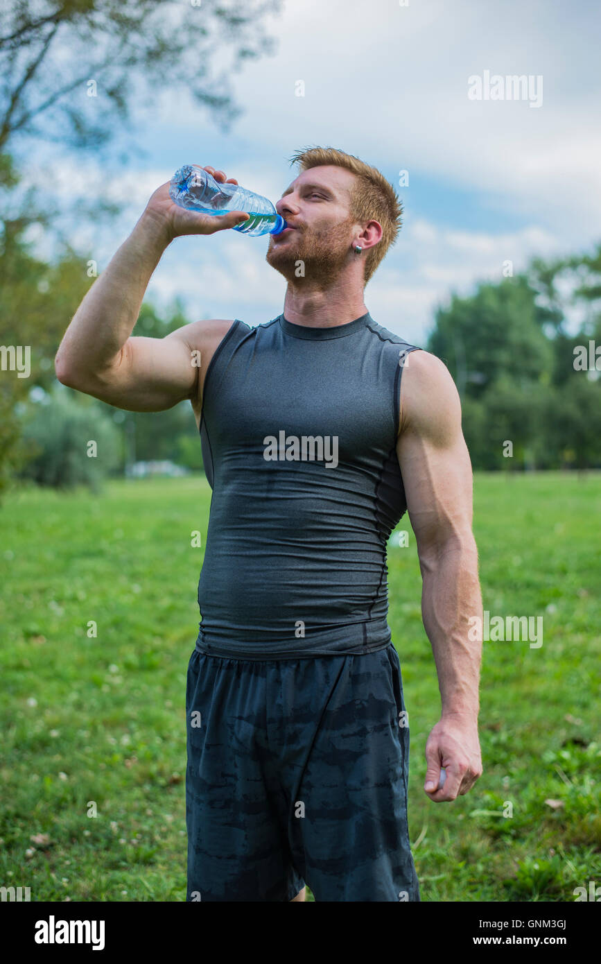 Athletische Sportart Man Trinkwasser aus der Flasche Stockfoto