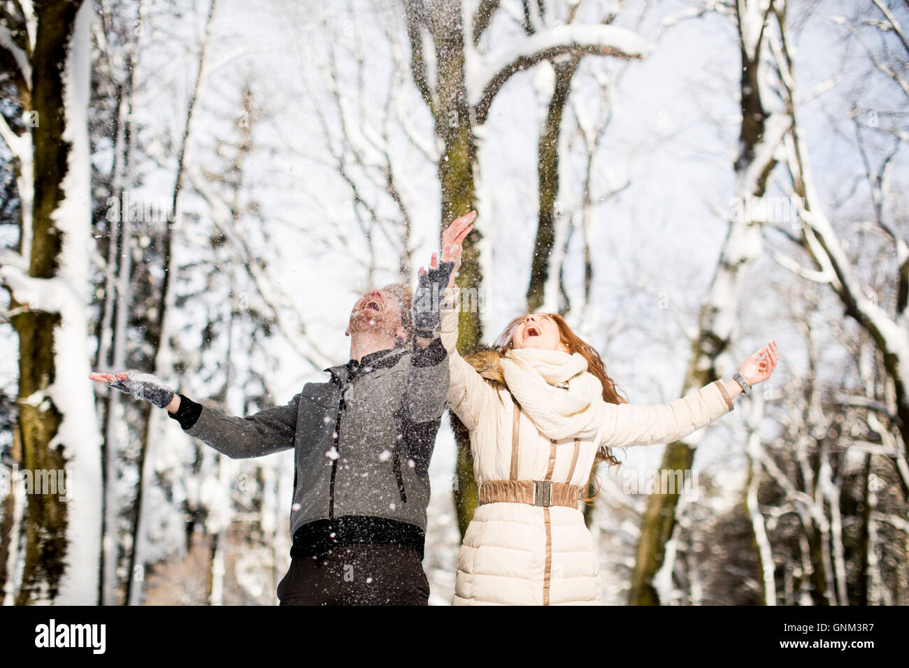Junge Paare, die Spaß im Schnee im park Stockfoto