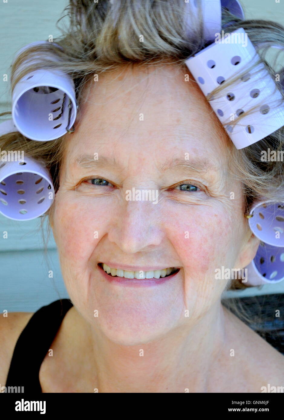 Weibliche Schönheit in Lockenwickler. Stockfoto