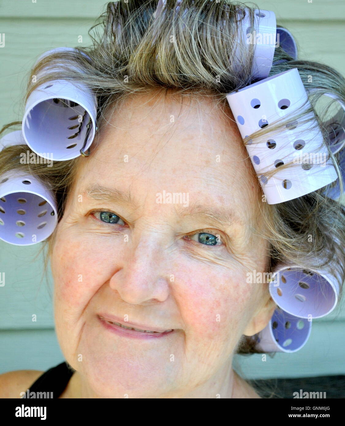 Weibliche Schönheit in Lockenwickler. Stockfoto