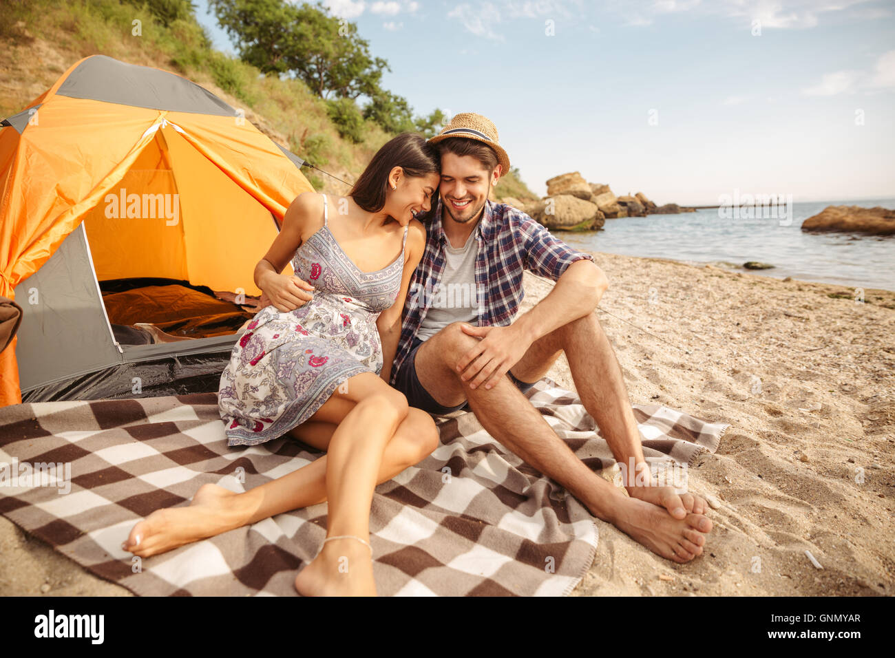 Junge schöne Brautpaar sitzen im Zelt am Strand Stockfoto