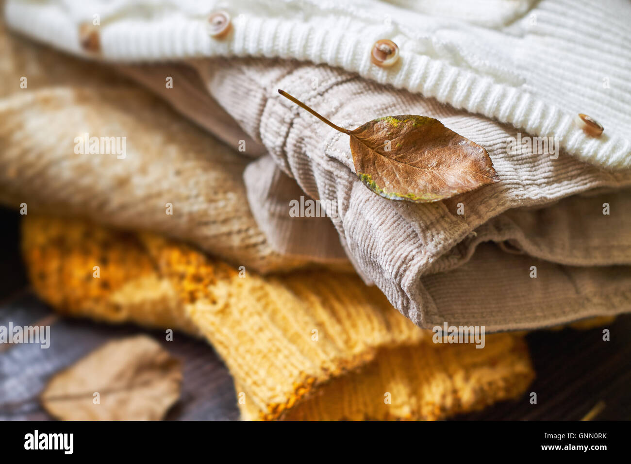 Stapel von Herbst Kleidung für Frauen auf hölzernen Hintergrund Stockfoto