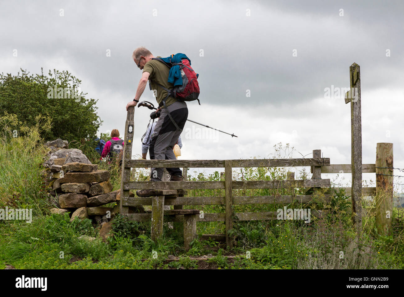 Cumbria, England, UK.  Wanderer durchqueren einen hölzernen Stil auf dem Hadrianswall Fußweg. Stockfoto