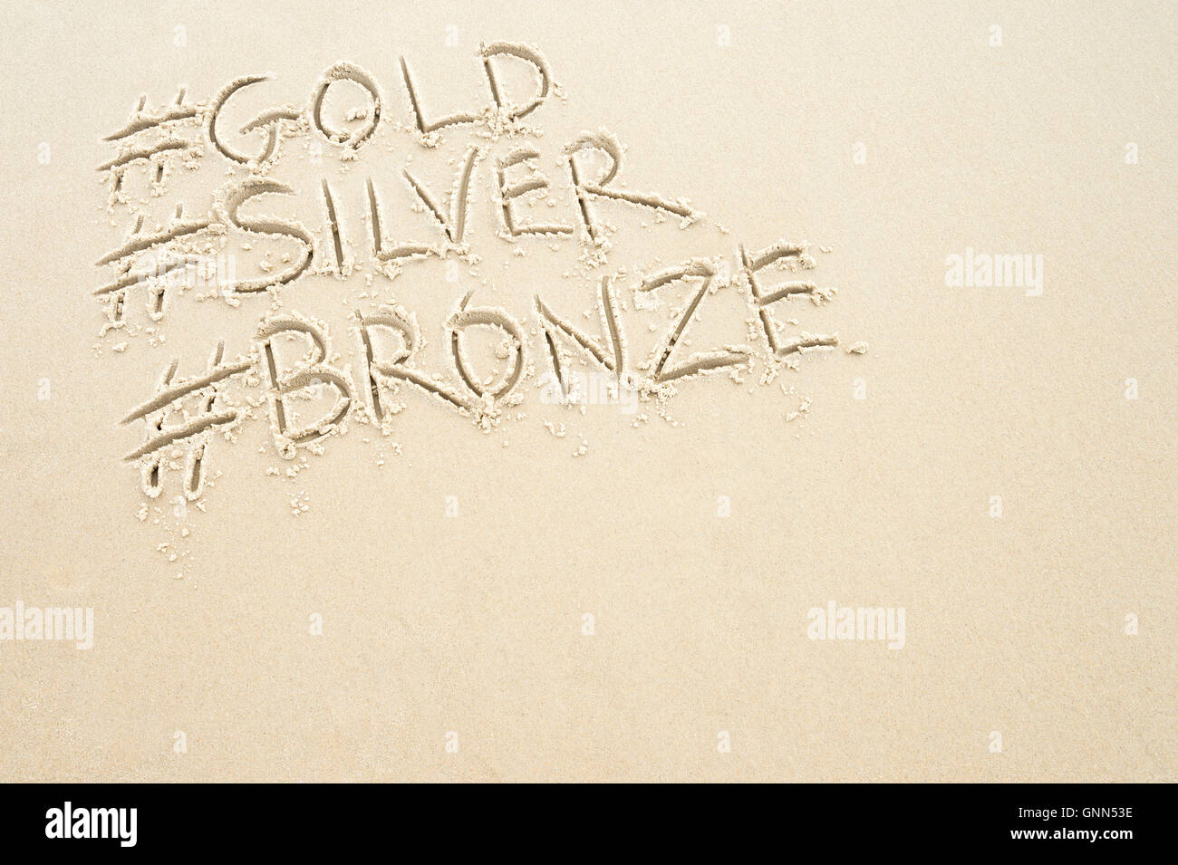 Hashtag-social Media-Nachricht für Gold-, Silber- und Bronze-Medaillen, Sport des ersten, zweiten und dritten Platz, in Sand geschrieben Stockfoto