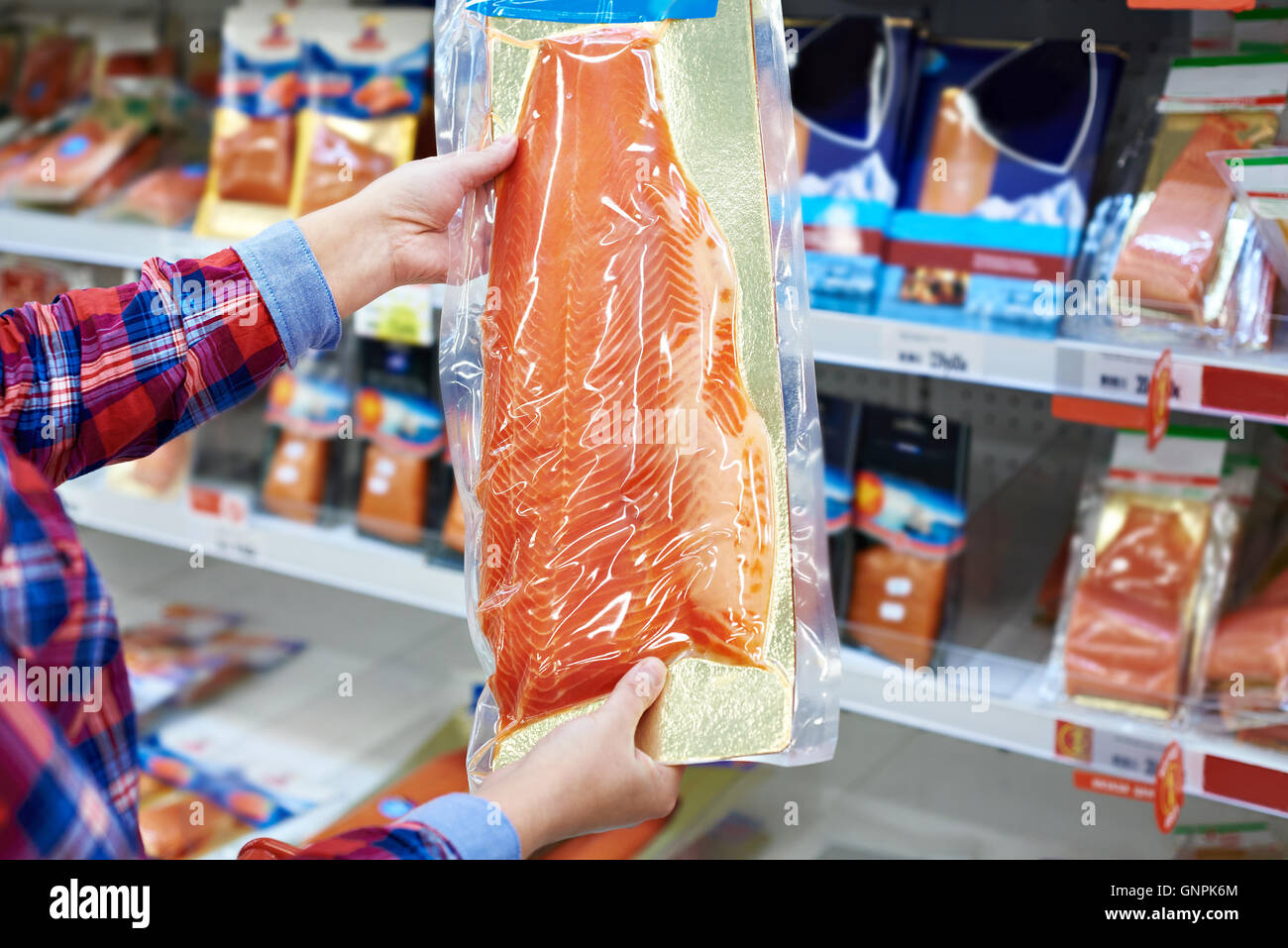 Frau kauft im Supermarkt Gesalzener Lachs Stockfoto
