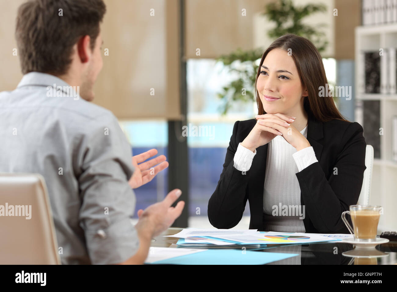 Geschäftsfrau, die Teilnahme an einen Kunden, der im Büro sprechen hören Stockfoto