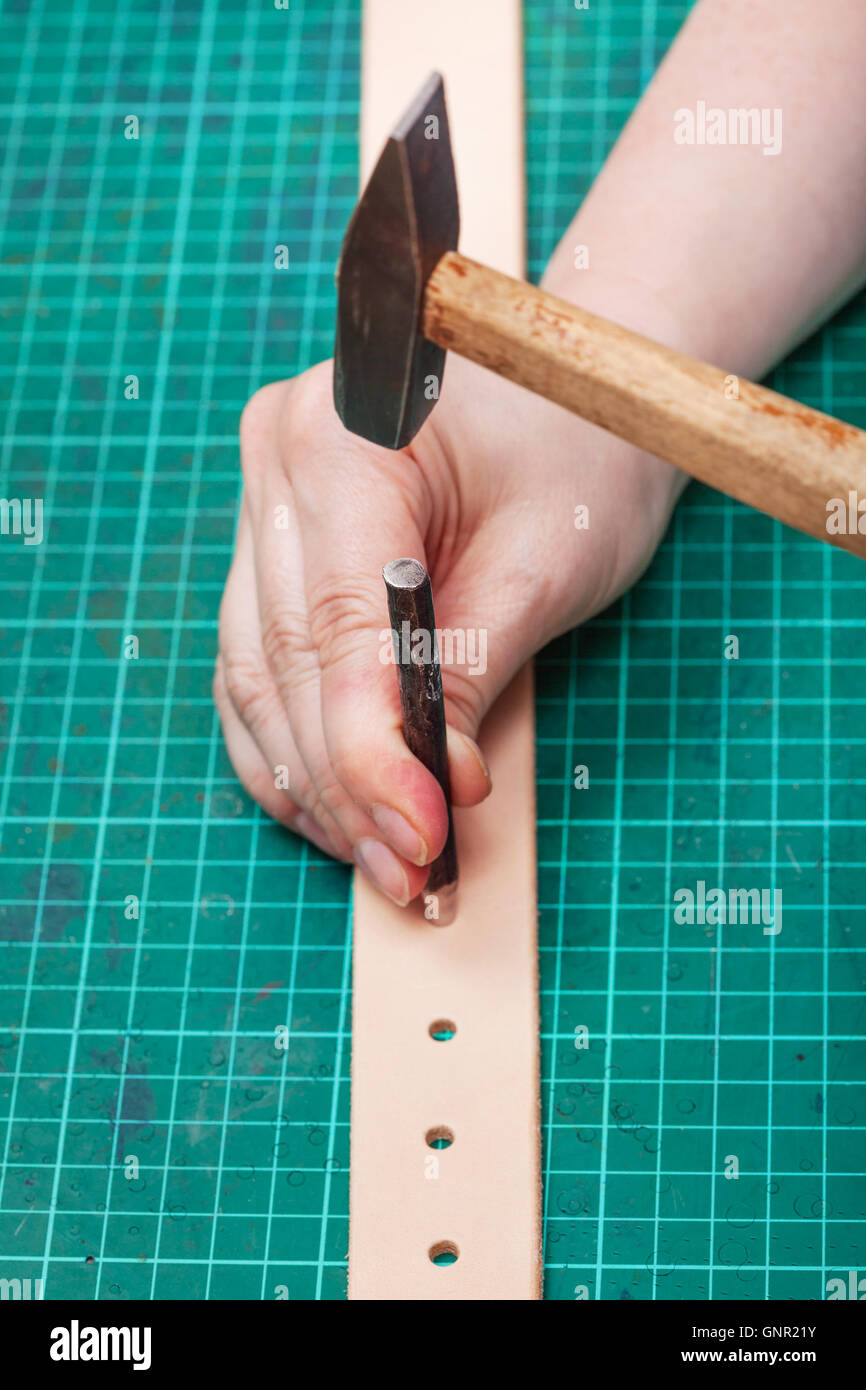fach-Lochung und Hammer machen Loch im Gürtel auf Self-healing mat  Stockfotografie - Alamy