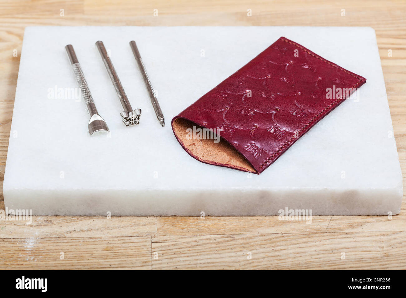 Portefeuille - neue handgemachte Leder-Etui für Brillen und Prägungen Werkzeuge auf Marmorplatte Stockfoto