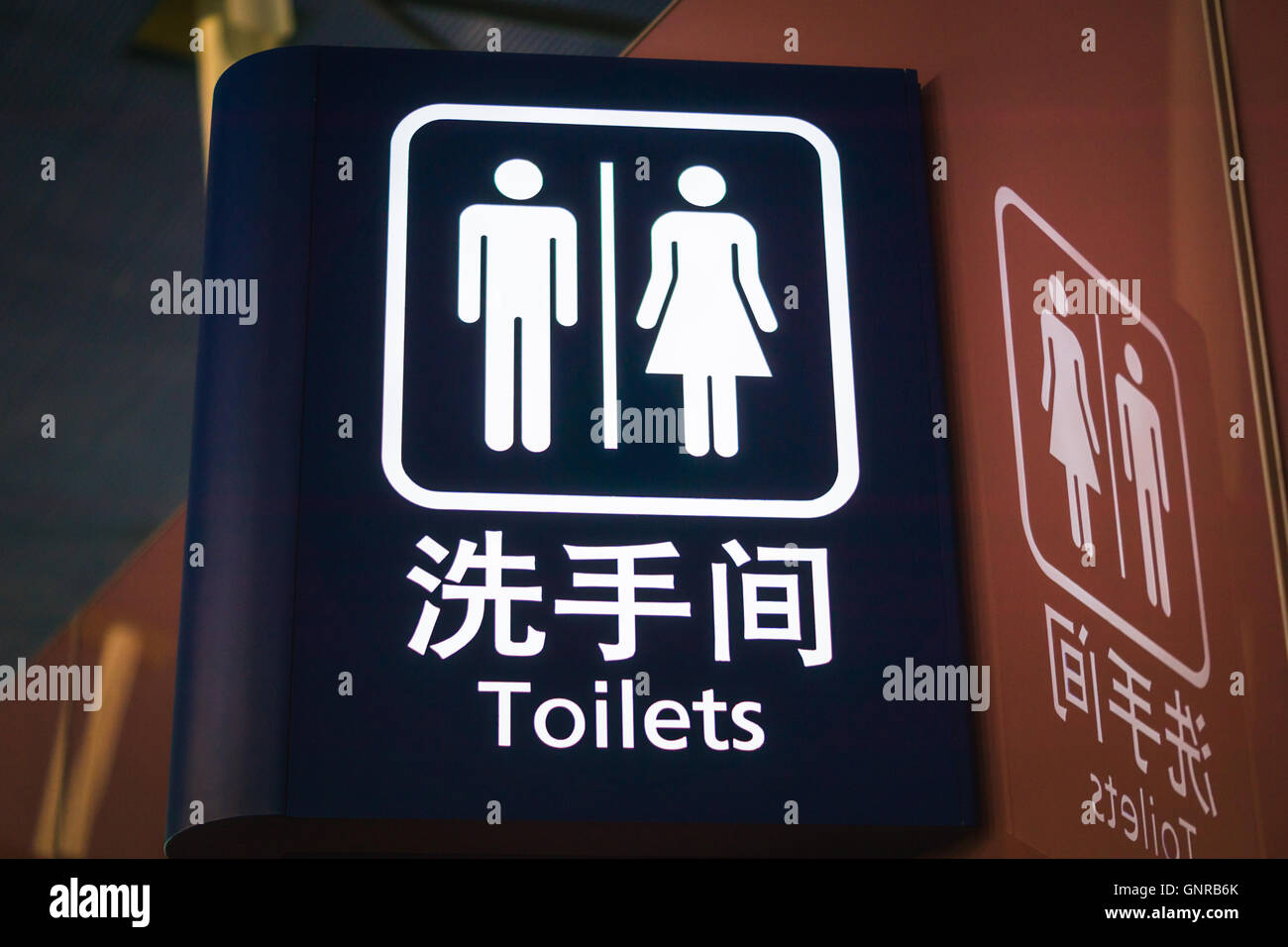WC-Zeichen und Symbol in Englisch und Chinesisch am Flughafen Stockfoto