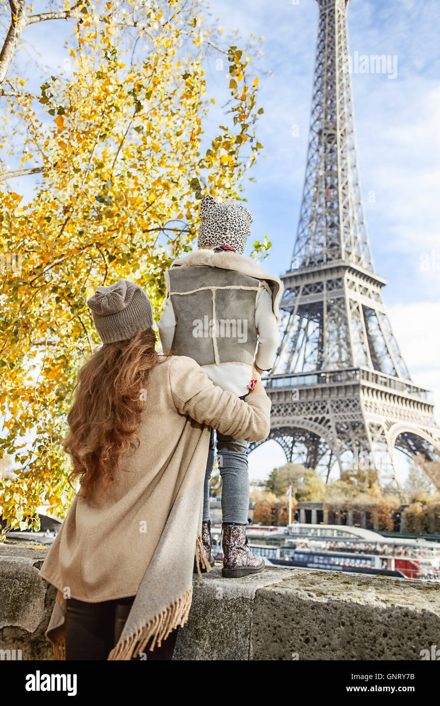 Herbst Kurzurlaube in Paris mit der Familie. Gesehen von hinten Mutter und Kind Reisende am Ufer in Paris, Frankreich am Eiffelturm Stockfoto