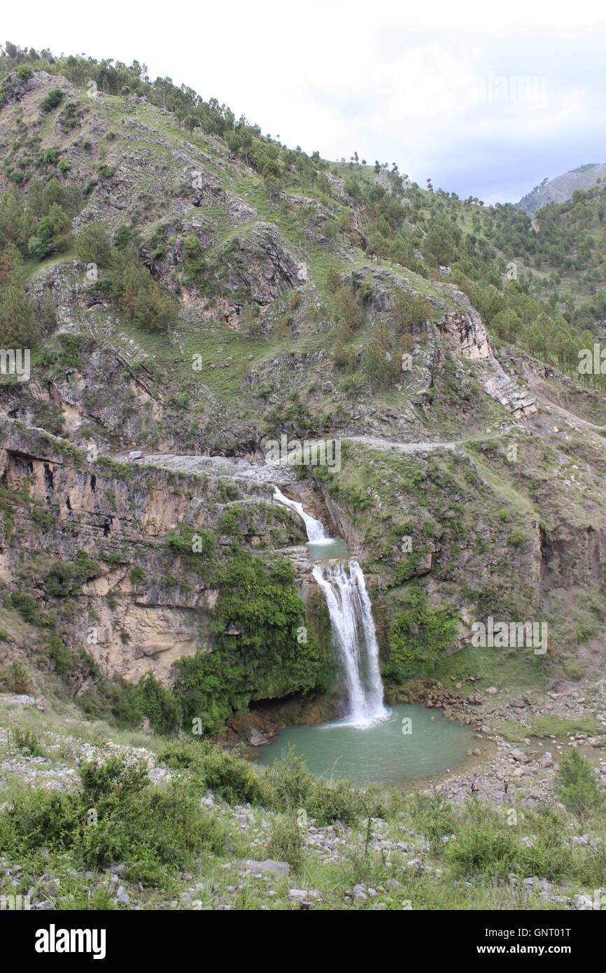 Ein Porträt-Modus Bild eines Wasserfalls am Fuße eines Berges Stockfoto