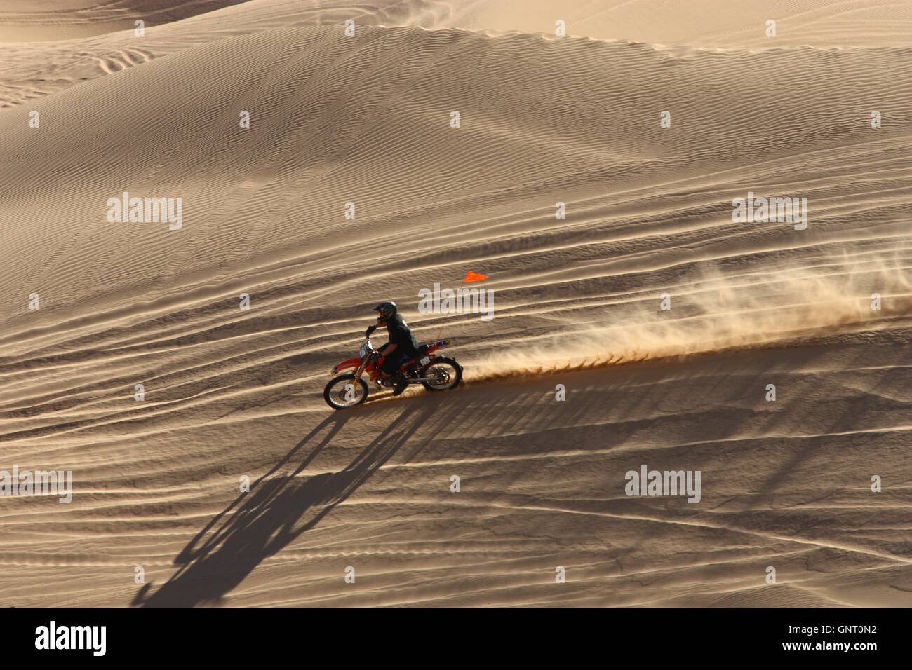 Off Road Enthusiasten fahren Dirt bike durch die riesigen Sanddünen in der Imperial Sand Dunes Recreation Area östlich von Imperial Valley, Kalifornien. Stockfoto